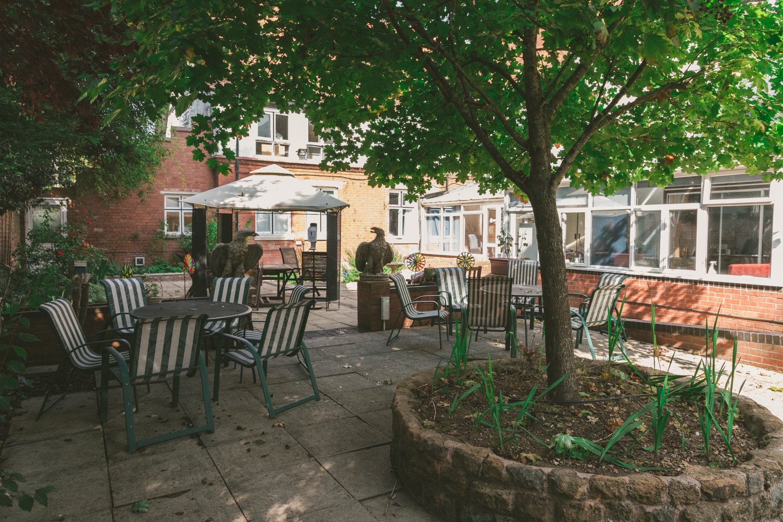 Patio seating area in the garden with table, chairs and greenery