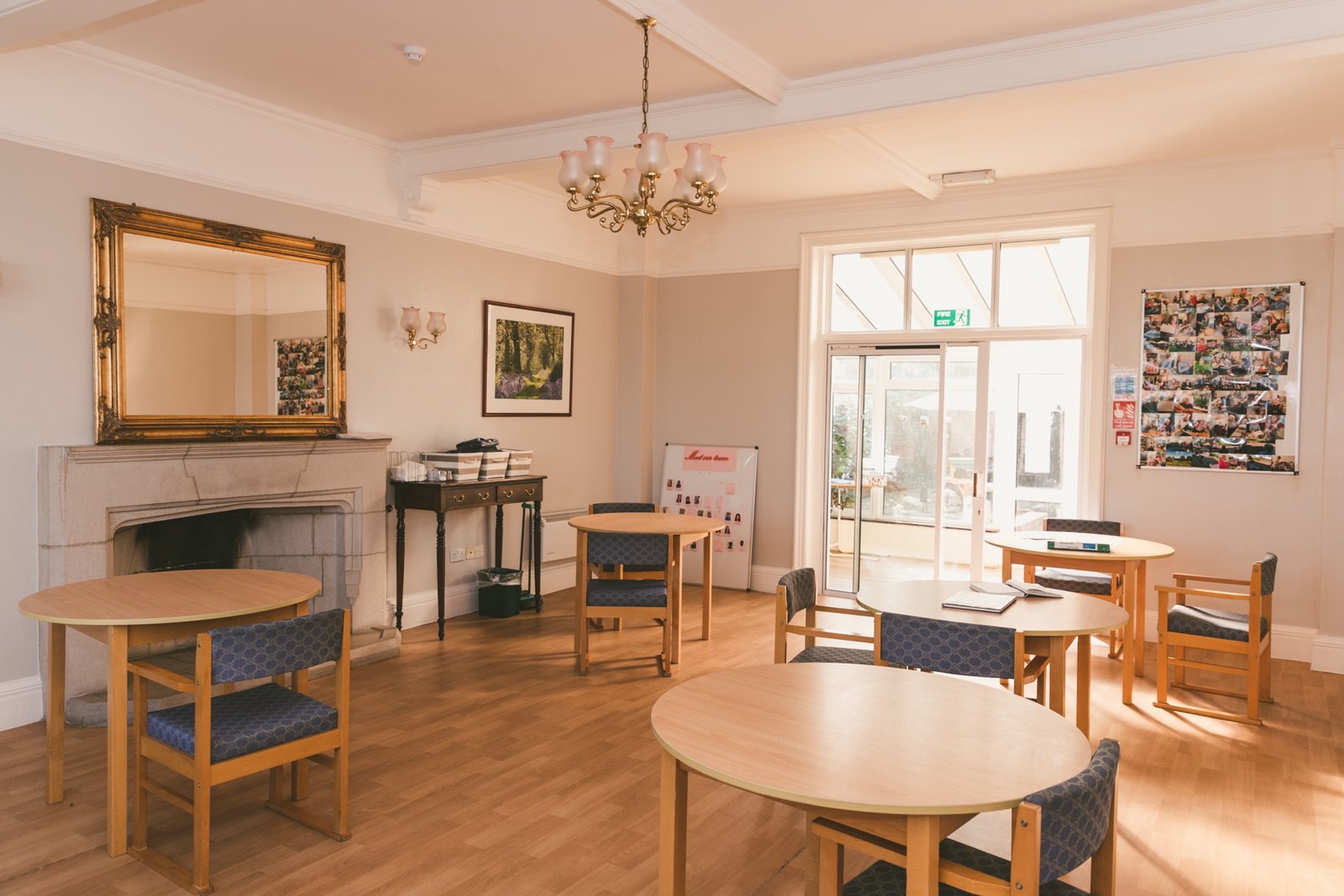 A cosy communal lounge with a fireplace and armchairs, softly lit