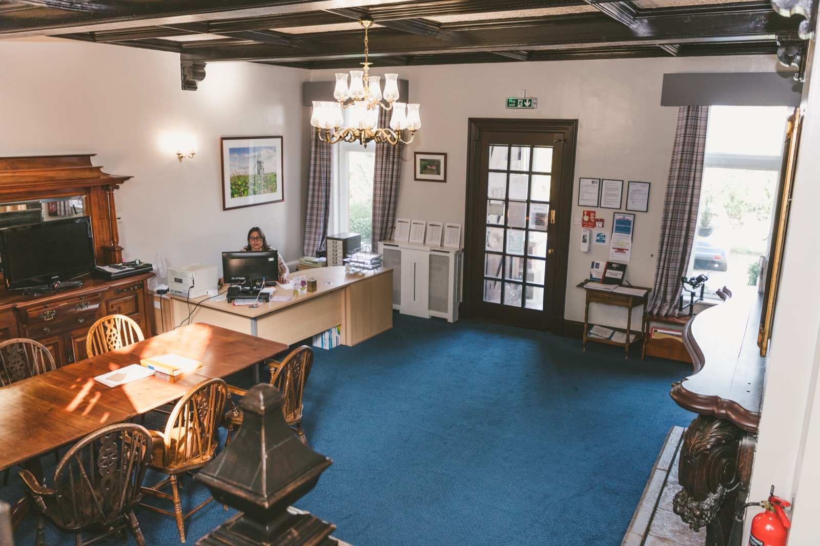 Traditional reception office with chandelier and beamed ceiling