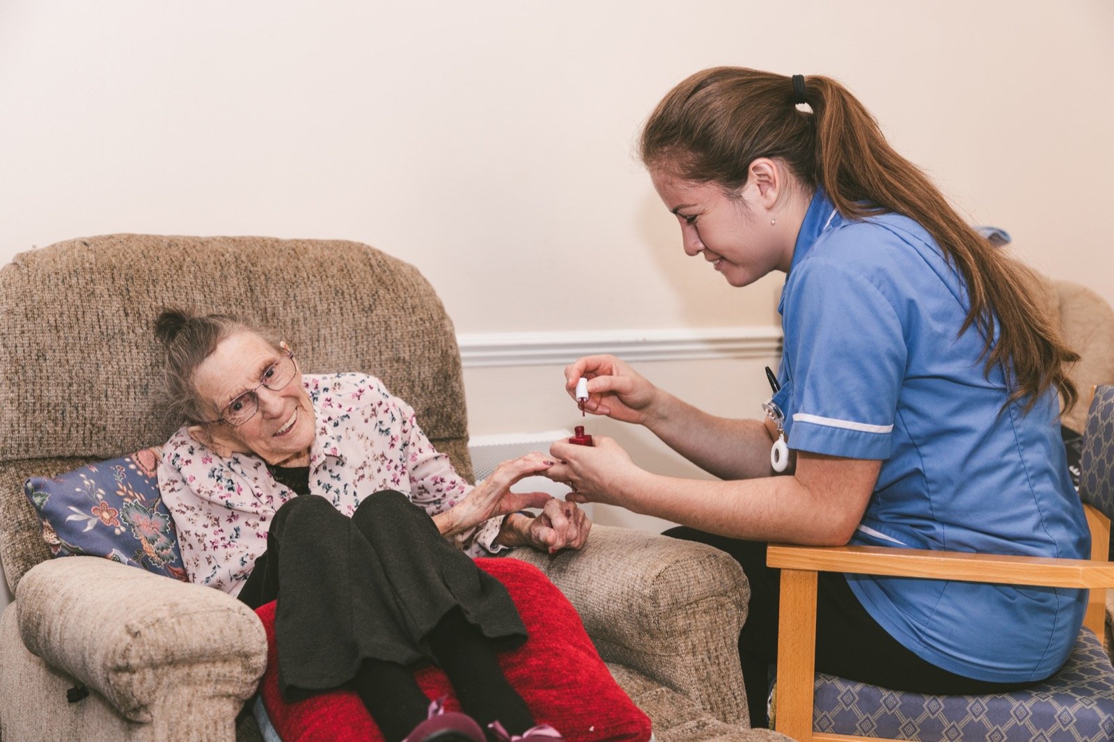 A carer gently painting a resident's nails